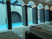 Glass-botton pool outside creates the ceiling of the spa pool inside (!).