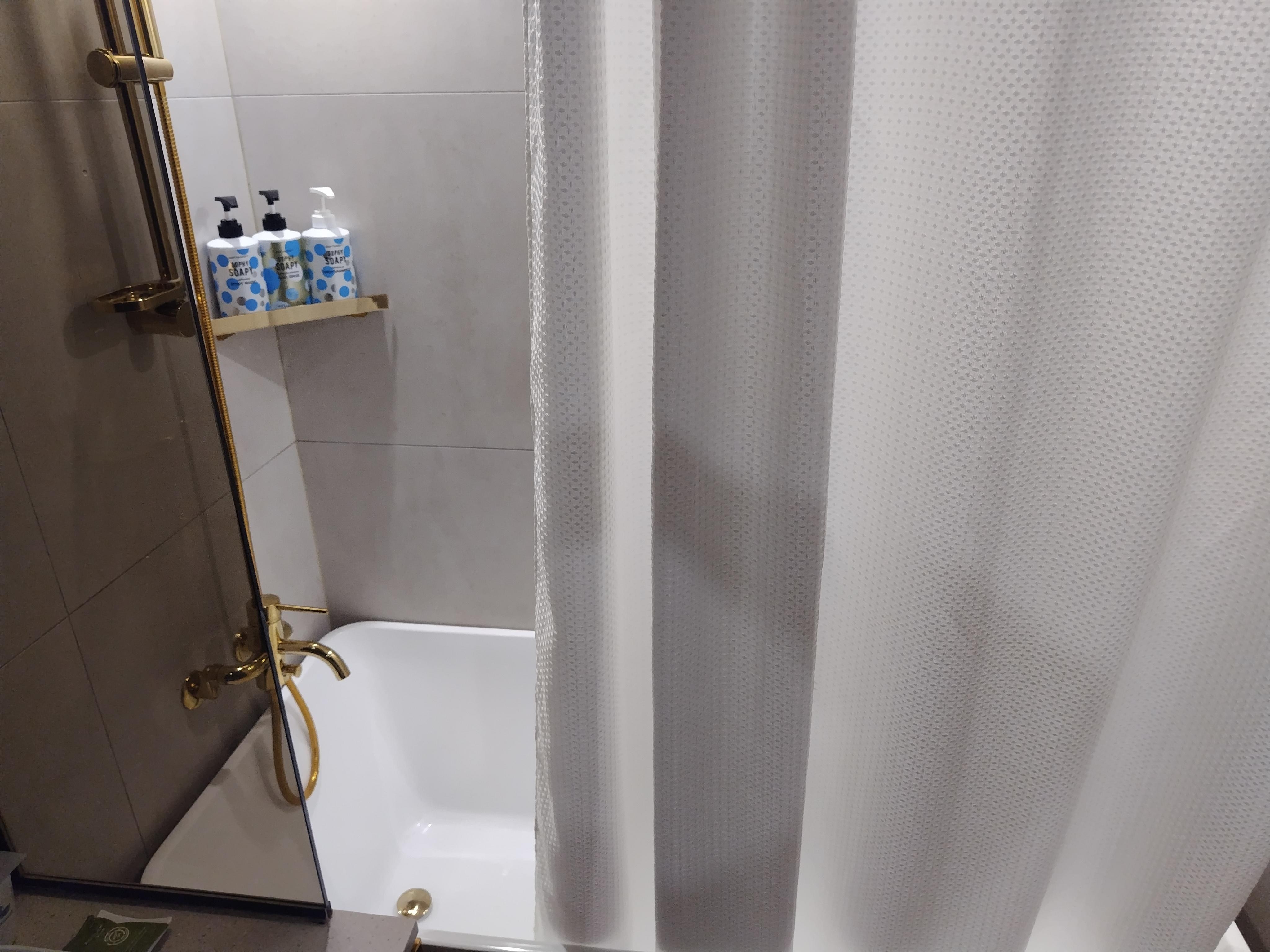 バスタブ付きでトイレと距離もあり、シャワーカーテンも清潔感アリ