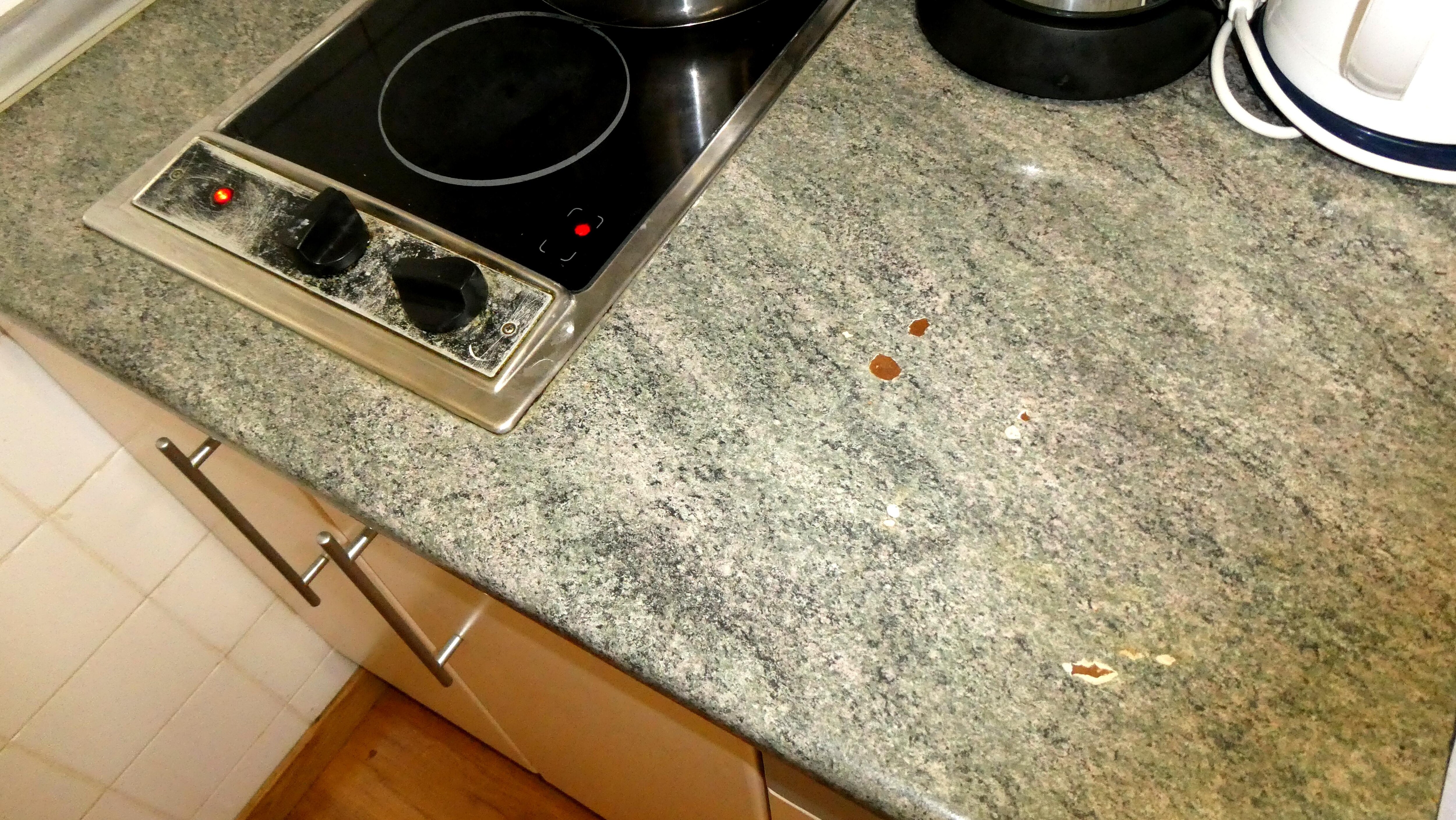 Le plan de travail a un certain nombre d'éclats. Quand à la plaque de cuisson, elle date d'un autre temps, et la vitre est dans un piteux état.