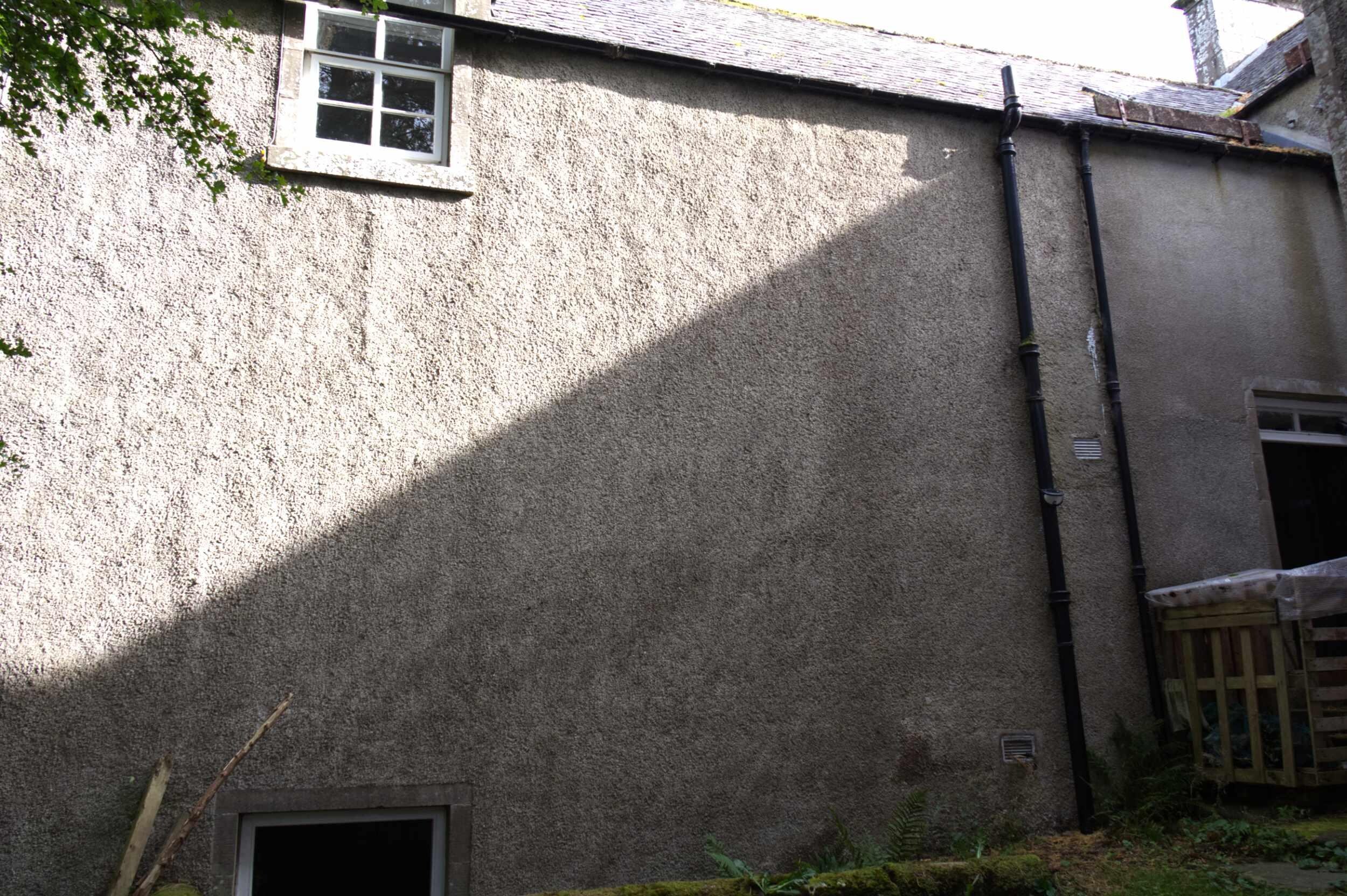 This is the side of the cottage showing the window to the main bedroom and front door on the right.