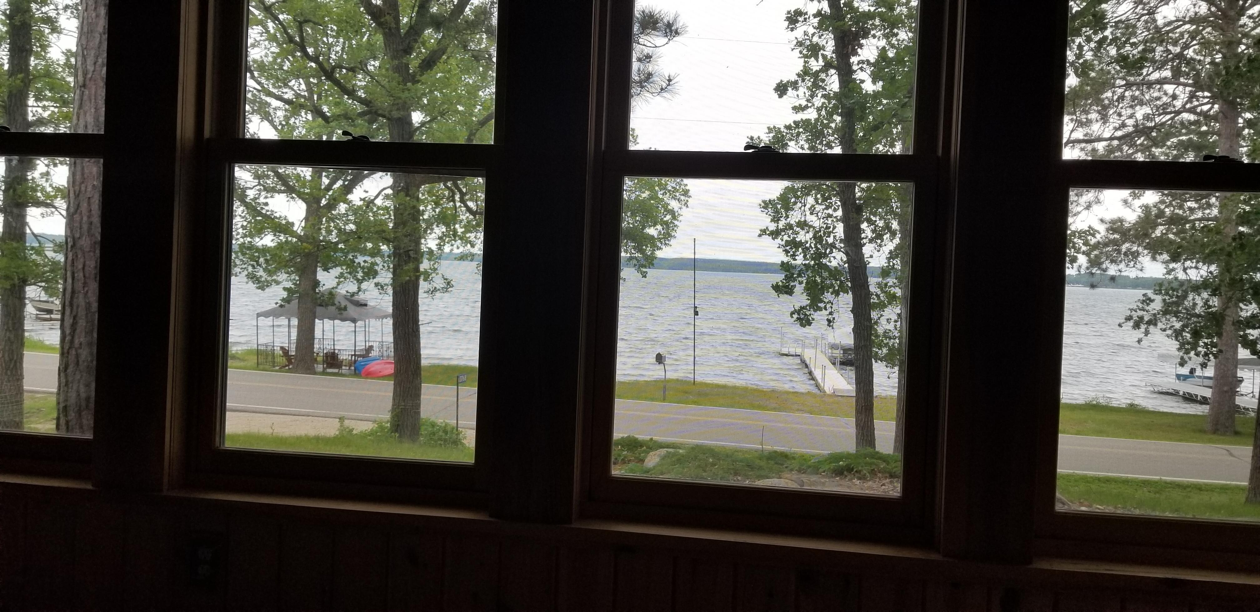 View from the front enclosed porch to the lake area with gazebo, kayaks and pontoon.