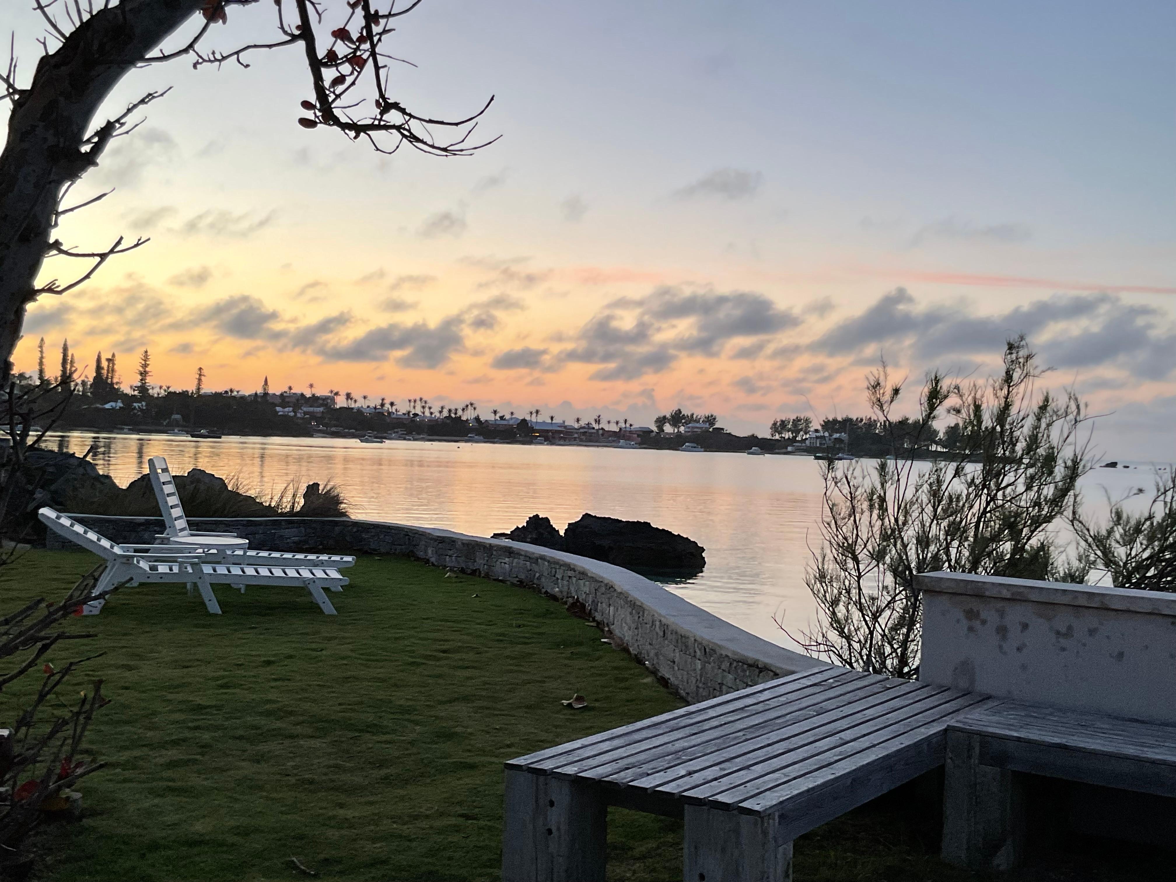 Great outdoor space including a small lawn and deck, with steps down to small beach.
