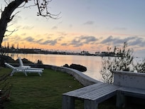 Great outdoor space including a small lawn and deck, with steps down to small beach.