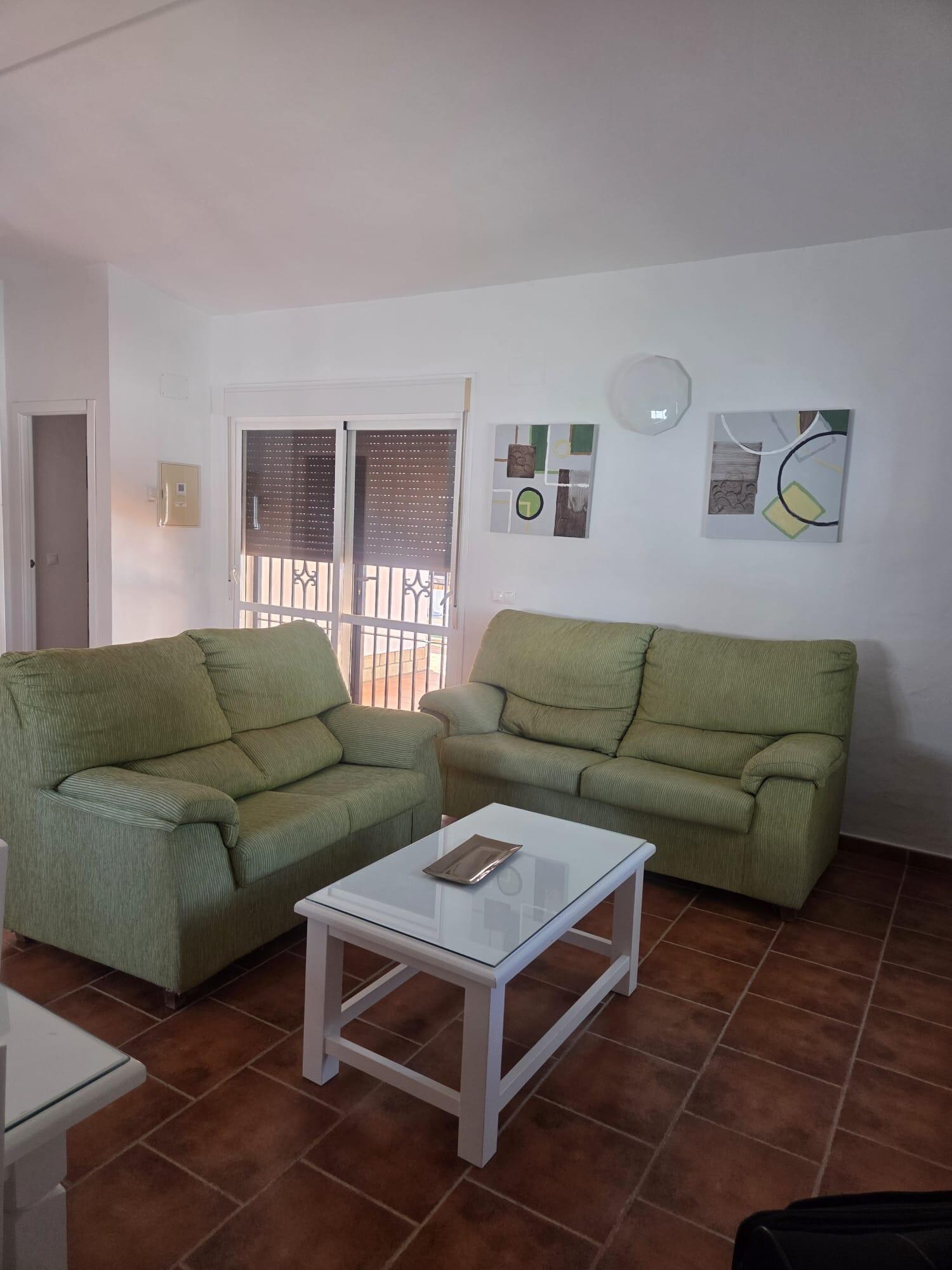 Offener Wohnbereich mit bequemer Couch und großem TV