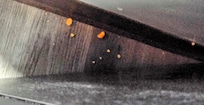 Chips on floor beside refrigerator visible, not behind it, on the side.