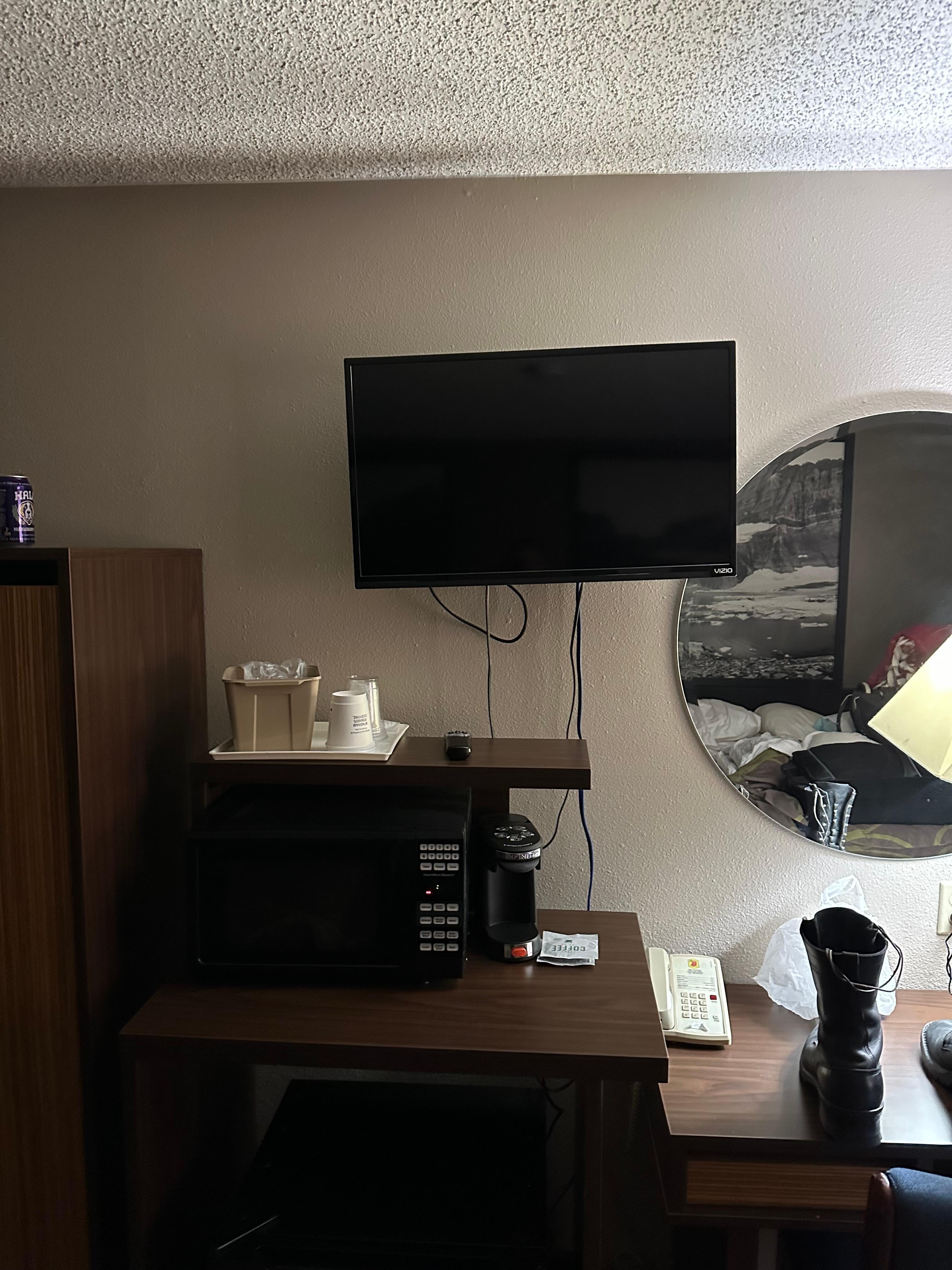 Tiny and unlevel tv with wires hanging out