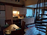 The quaint kitchen dining are is perfectly stocked and played out for a food gathering place and openess to allow visiting with anyone in the living room anointed as well.