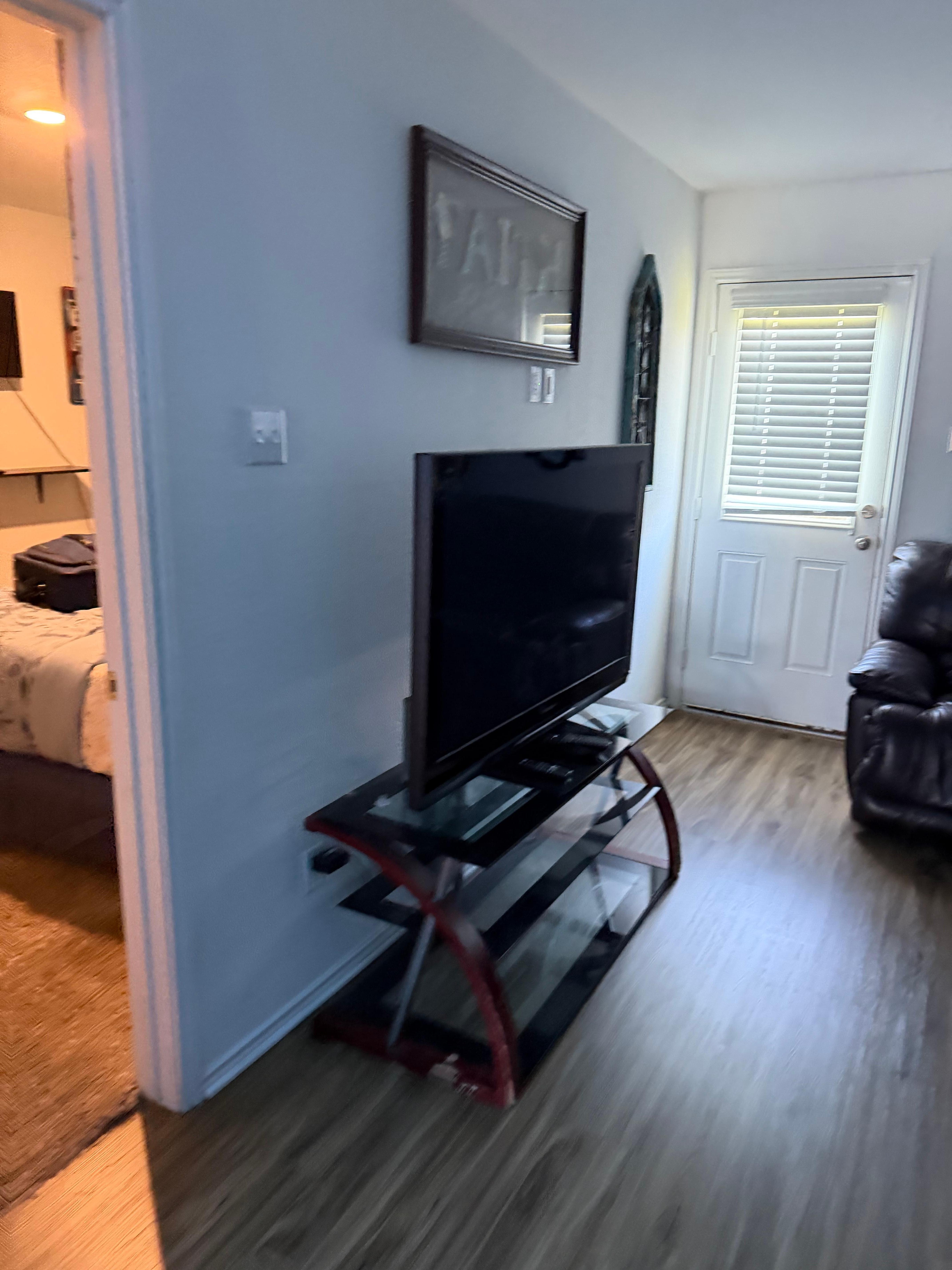 Living room TV and back door that goes out to a fenced in yard with 4 rocking chairs, nice!