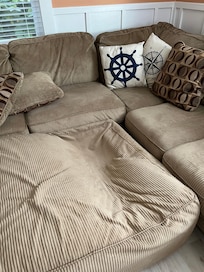 Broken ottoman with signs of previous repair attempts underneath it.