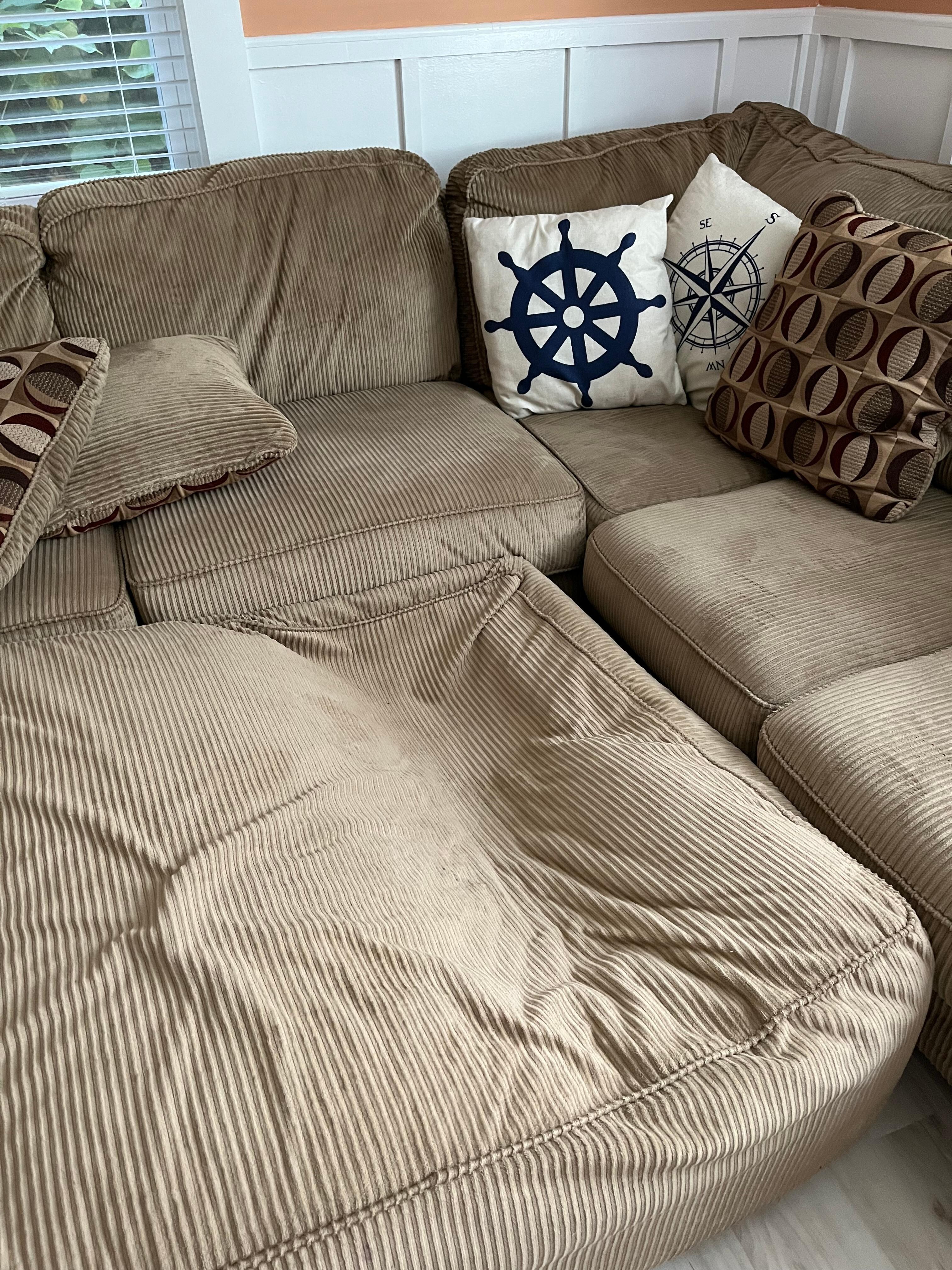 Broken ottoman with signs of previous repair attempts underneath it.