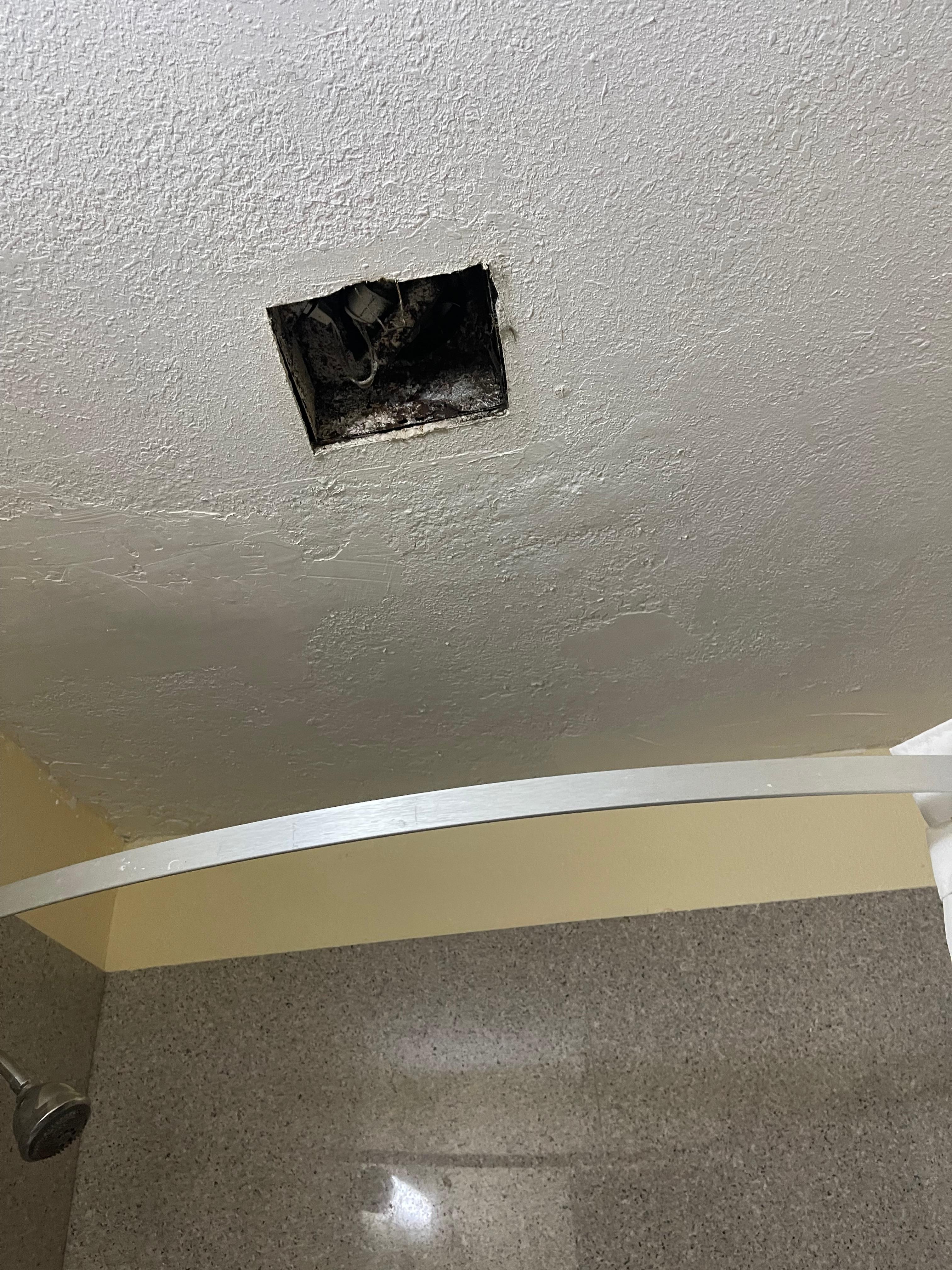 Hole in ceiling of the bathroom, where the fan was