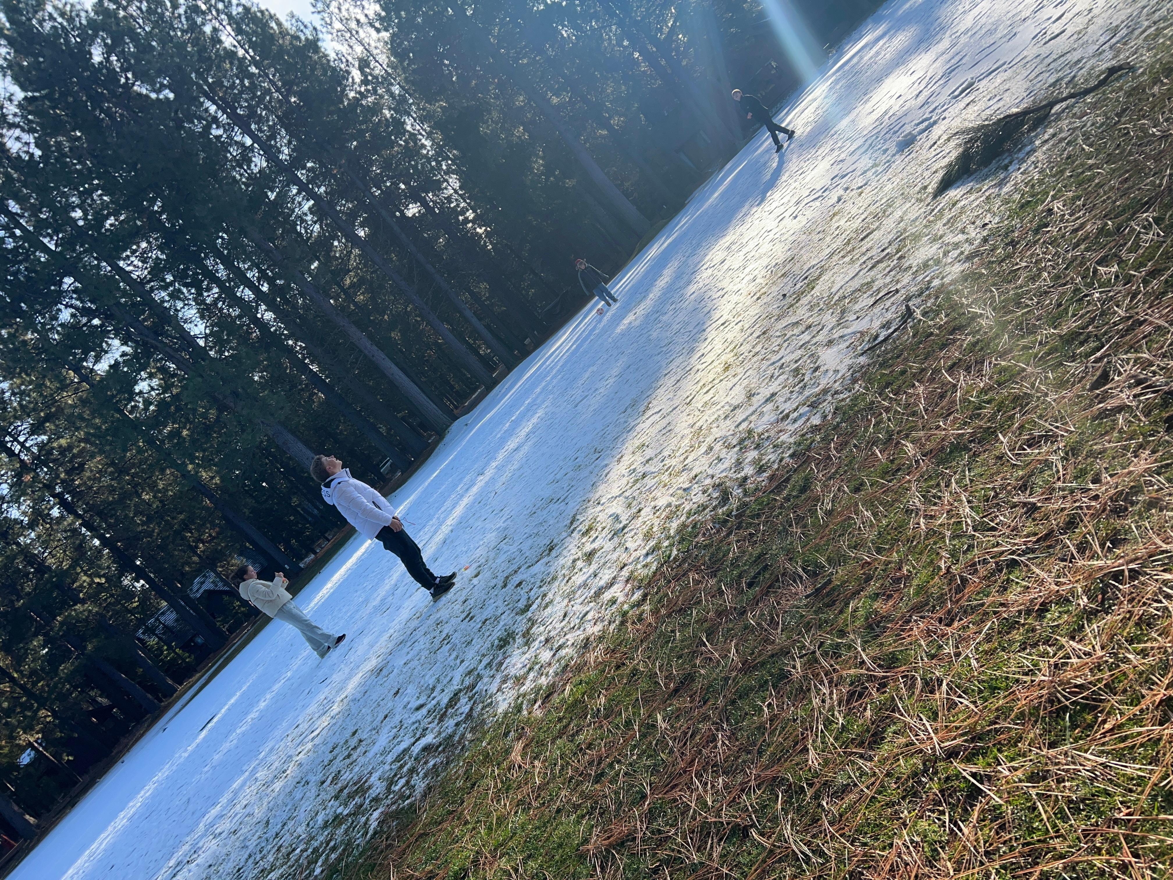 Kids play in snow on golf course