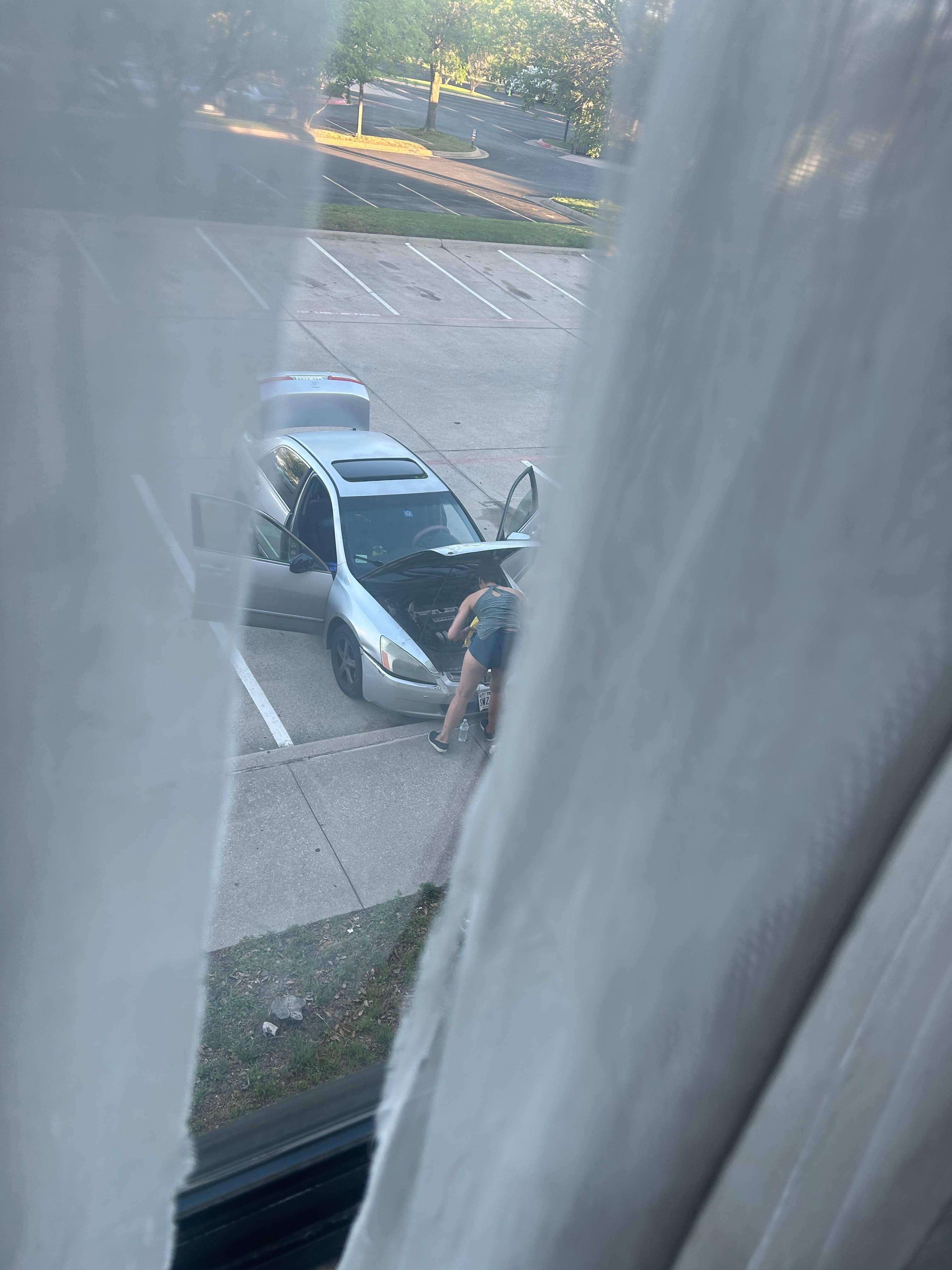 Person working on car in the parking lot