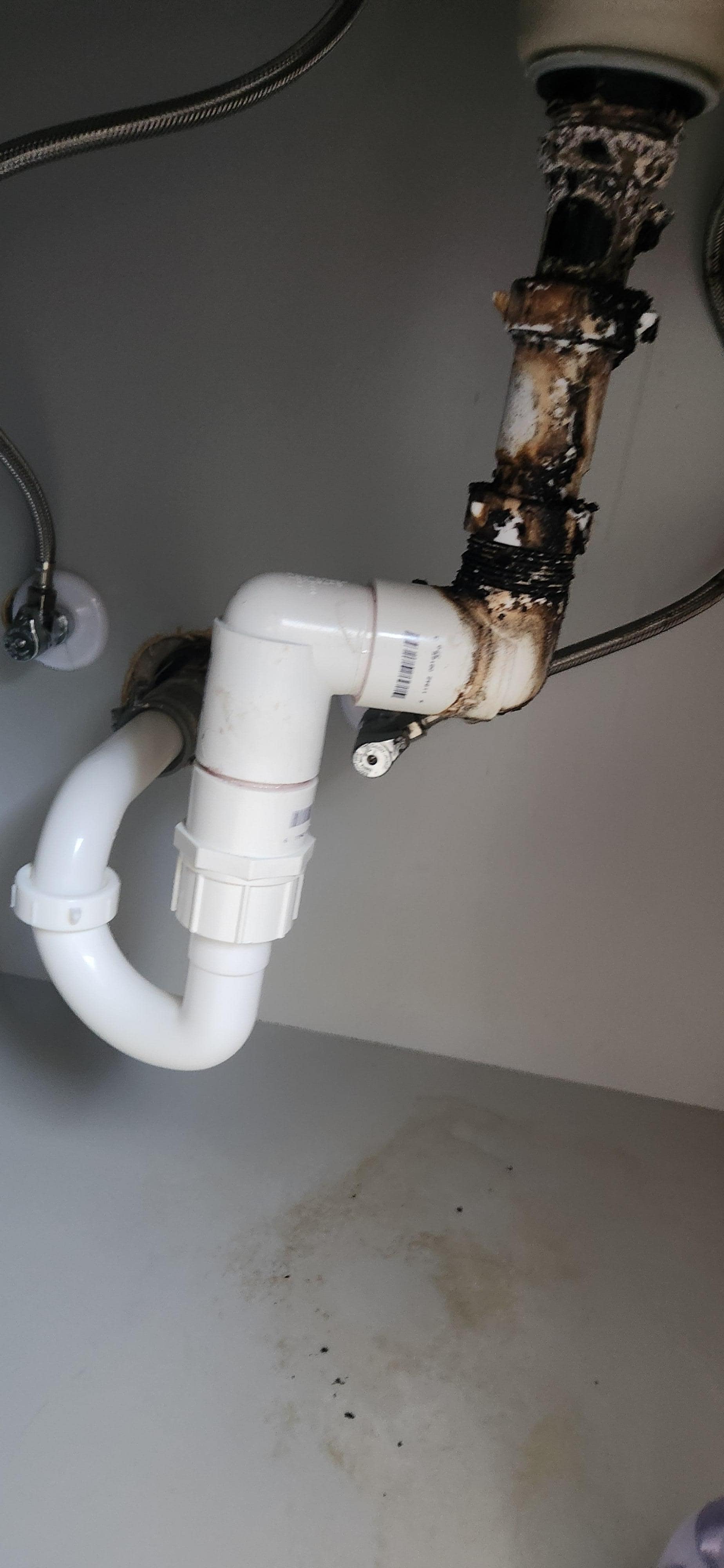 Molded leaking sink drain pipe dripping water out onto the floor making it slippery and dangerous, cabinet unusable
