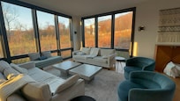 Floor to ceiling windows in family room with amazing view of fall color
