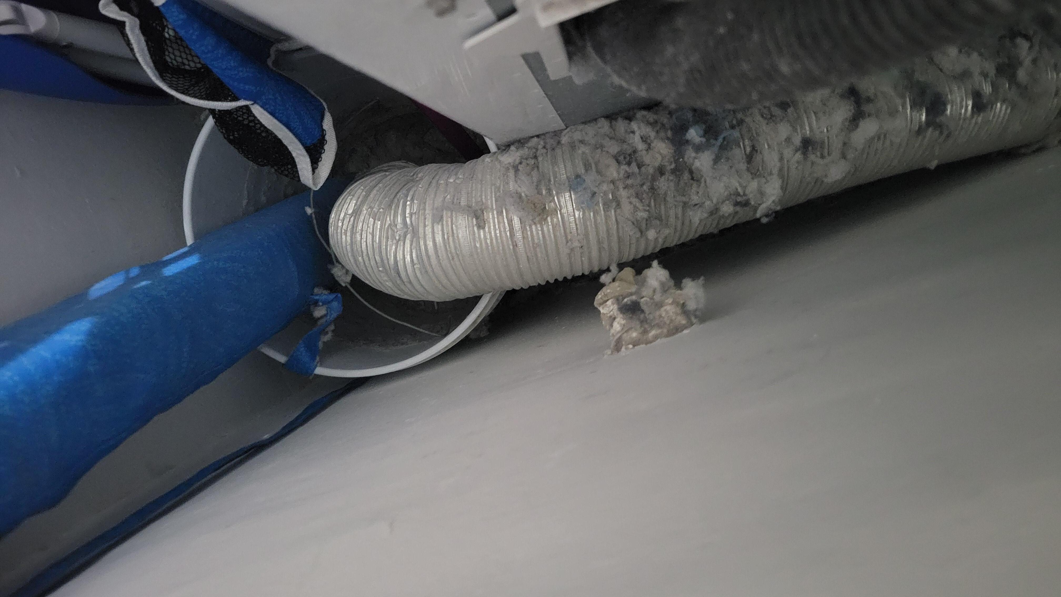 Vent Line from Gas Dryer exhausting into bucket, Flamable lint and dryer material from a long time being used like this exhausting into the air inside the apartment collected on top of everything.