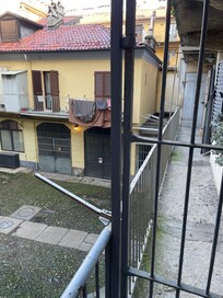 Narrow dark concrete walkway to access door.