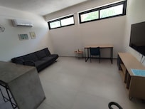 Sala de estar de buen tamaño, escritorio, sillón, aire acondicionado, pantalla con todas las amenidades.