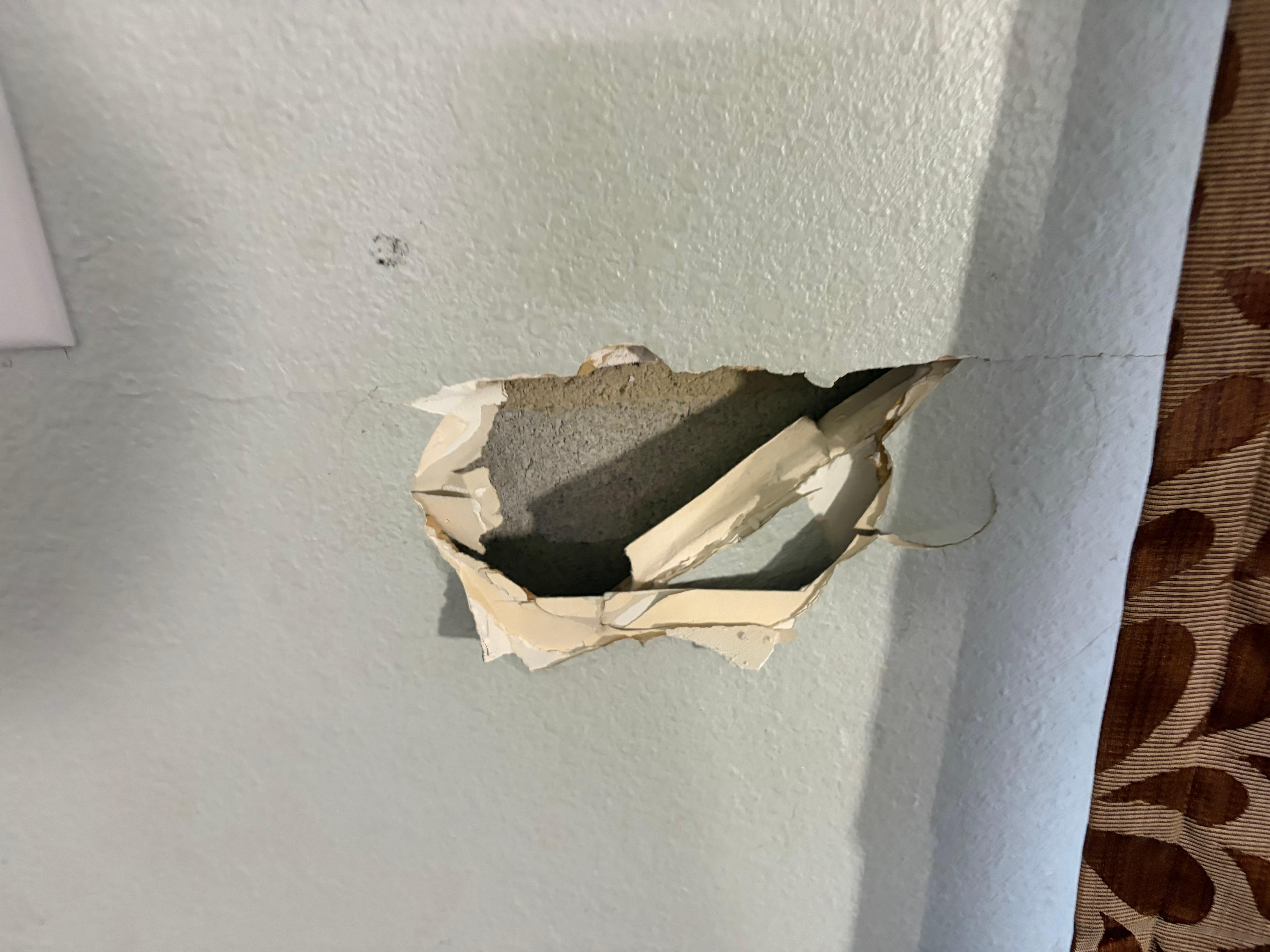 Large hole in wall beside the front door.