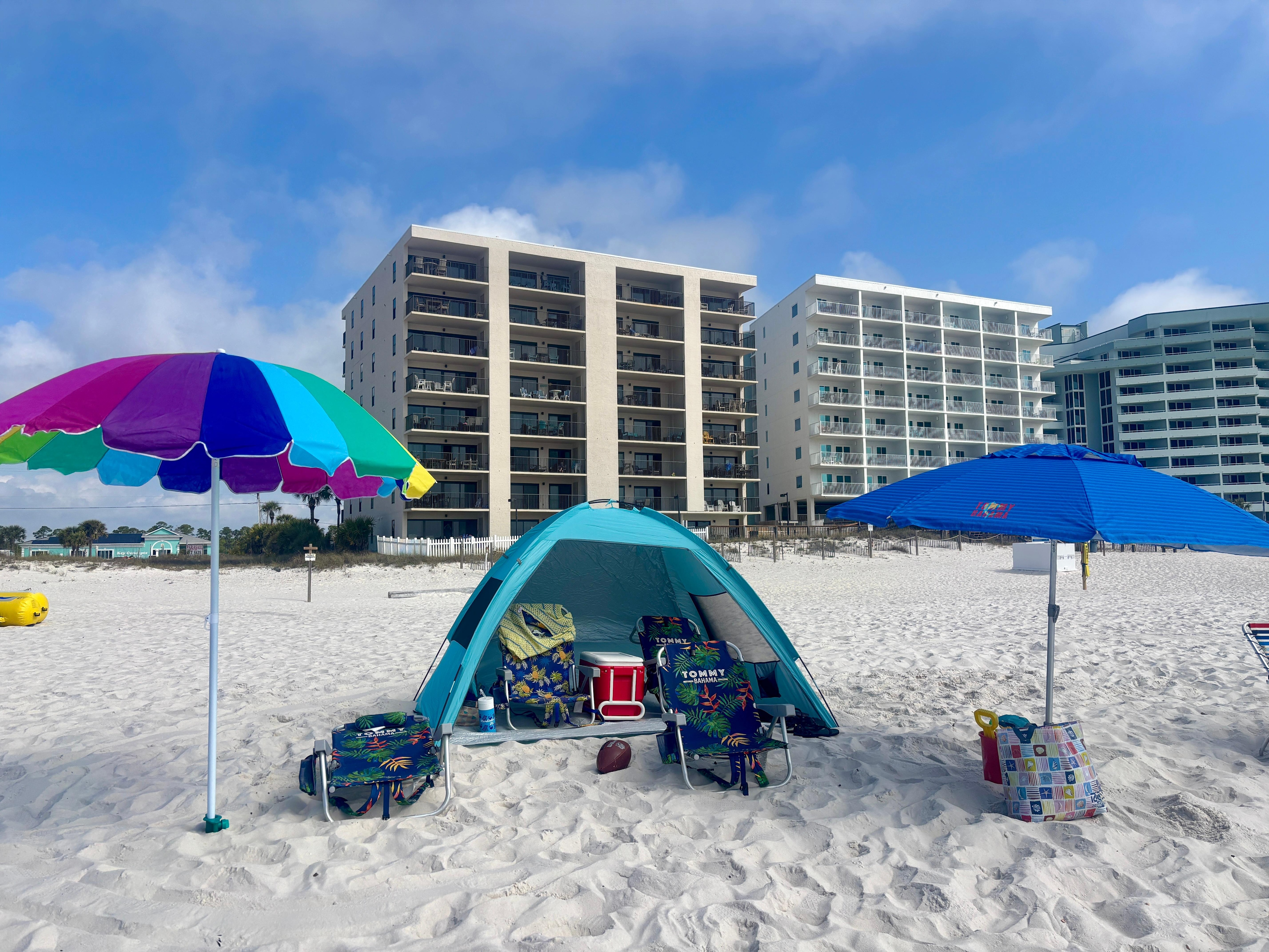 Our beach set up using only items from the condo- chairs, umbrellas, beach tent, red cooler, sand toys in a tote bag, football, towels