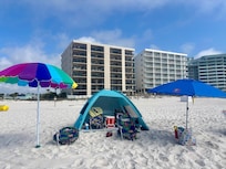 Our beach set up using only items from the condo- chairs, umbrellas, beach tent, red cooler, sand toys in a tote bag, football, towels
