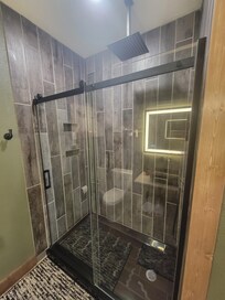 Barn door shower door, rain shower head and hand held sprayer.