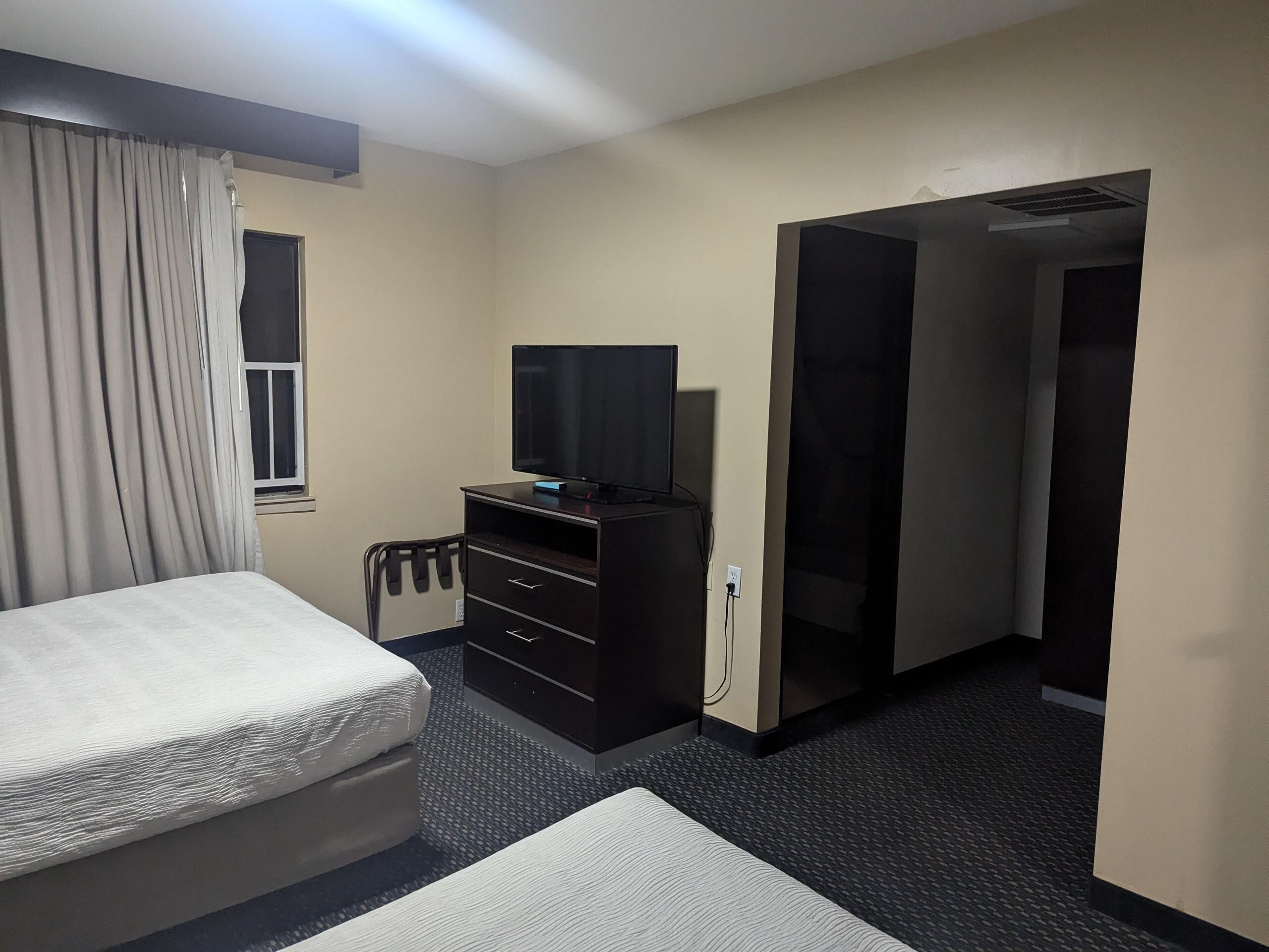 Bedroom leading to bathroom and closet. Notice the bottom drawer is missing a handle.