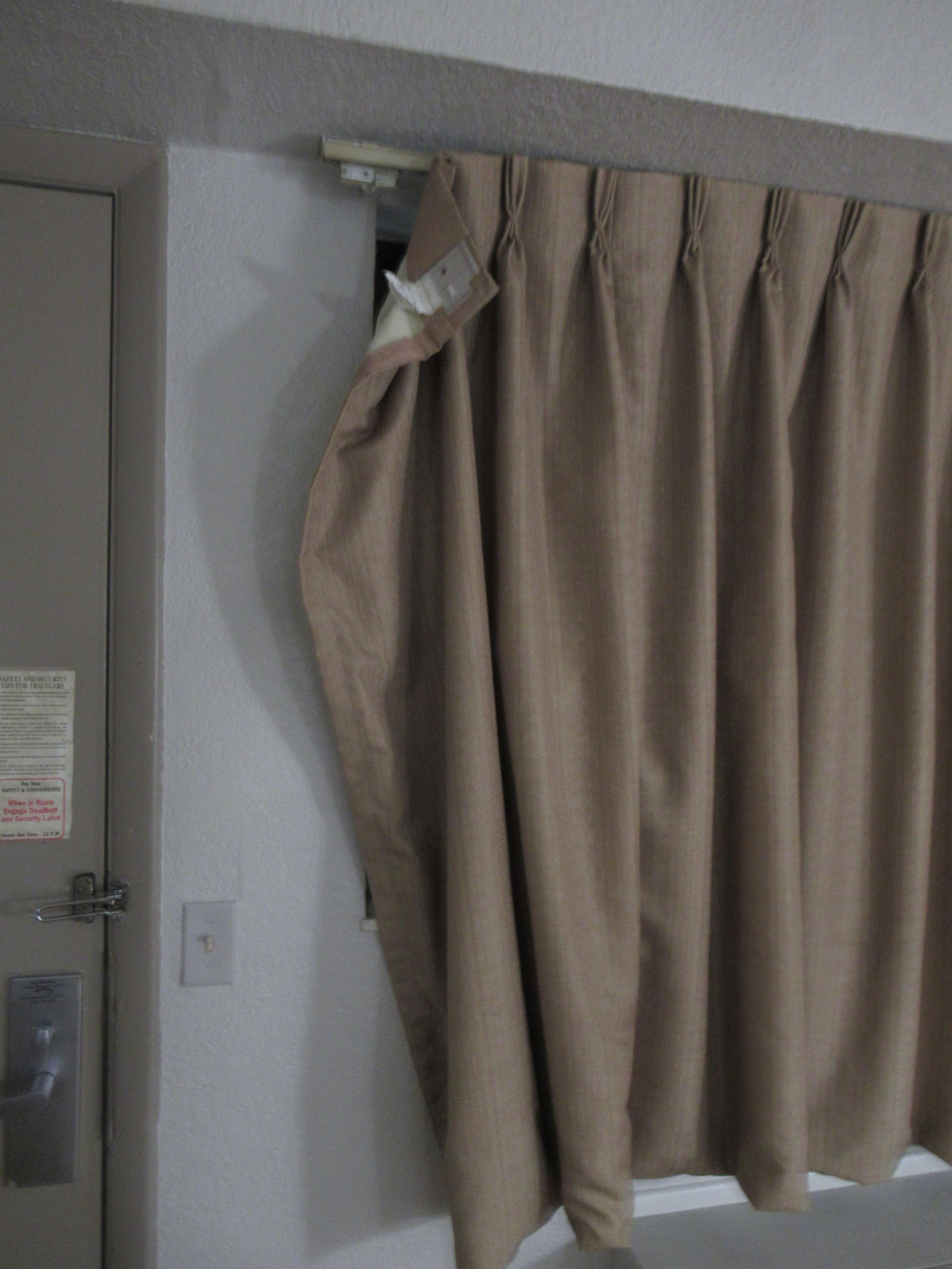 Curtains holding up by a thread.