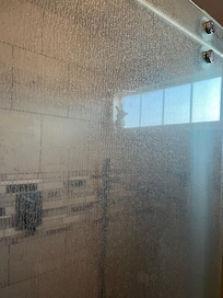 Soap scum solid on both doors inside shower…