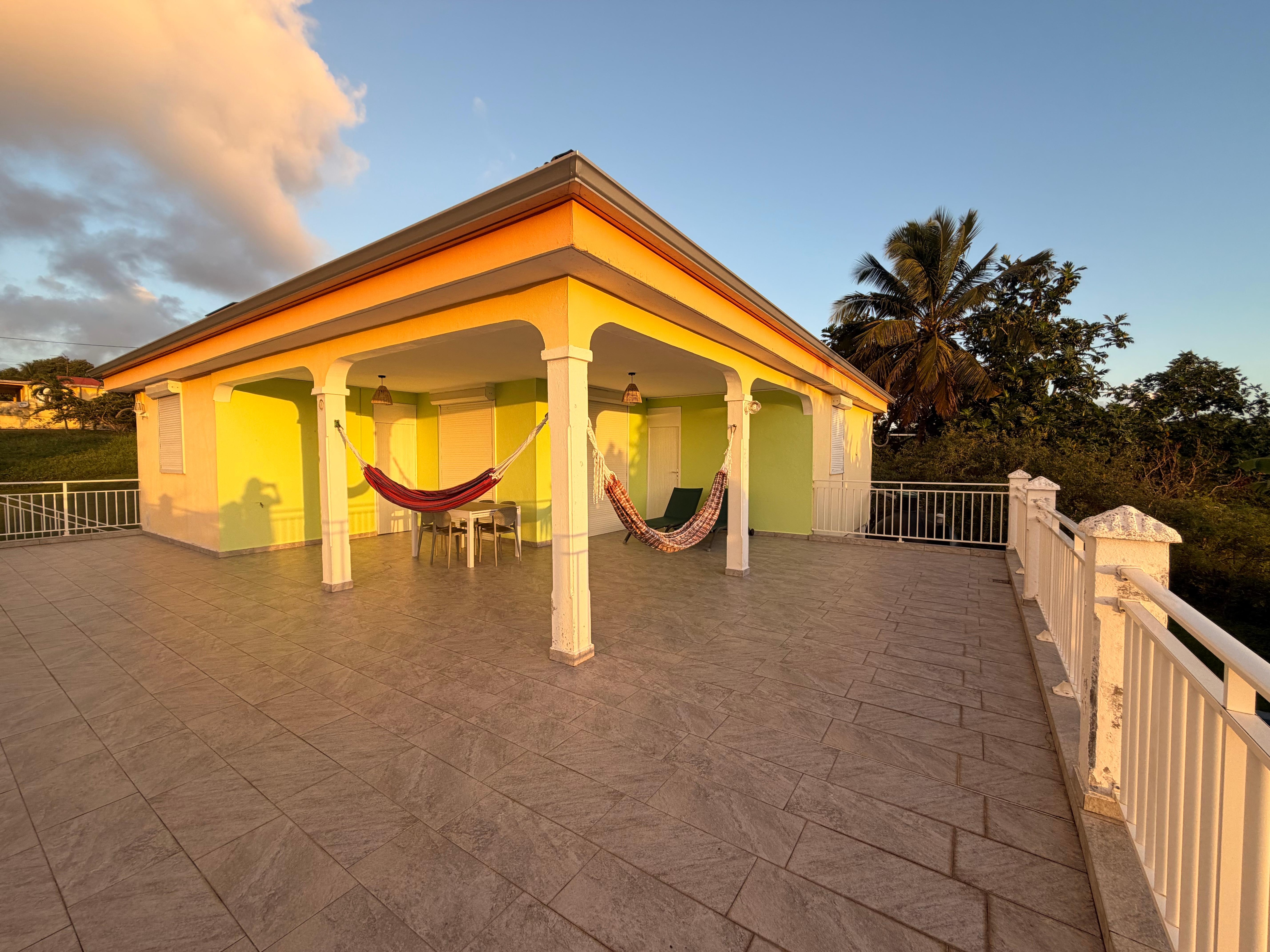 Vaste terrasse avec 2 hamacs, 2 transats et table avec 6 chaises