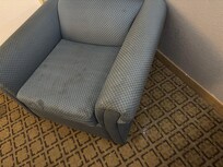 Stained chair with spilled food on floor adjacent.
