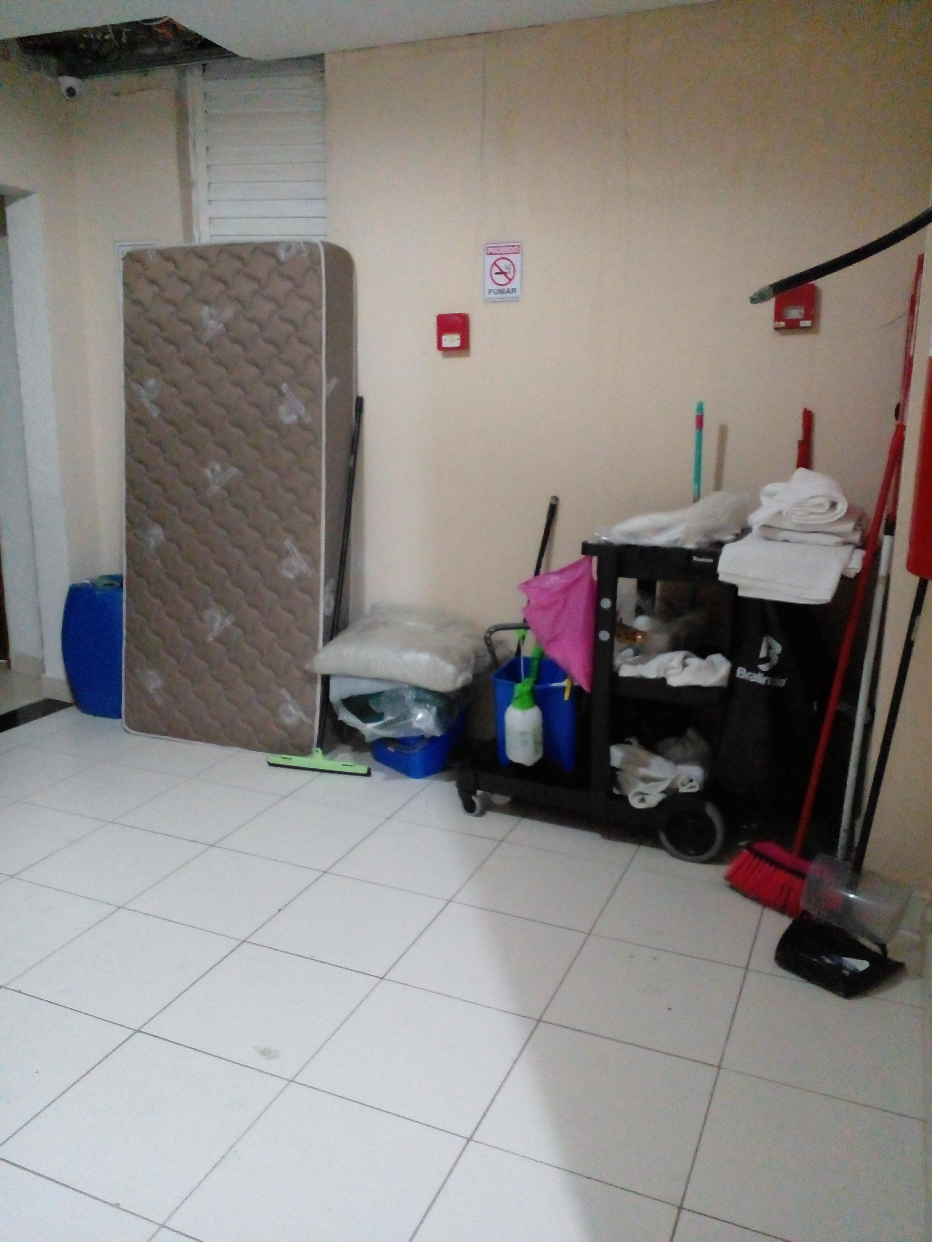 Itens  de limpeza e colchão  deixados  entre os quartos
