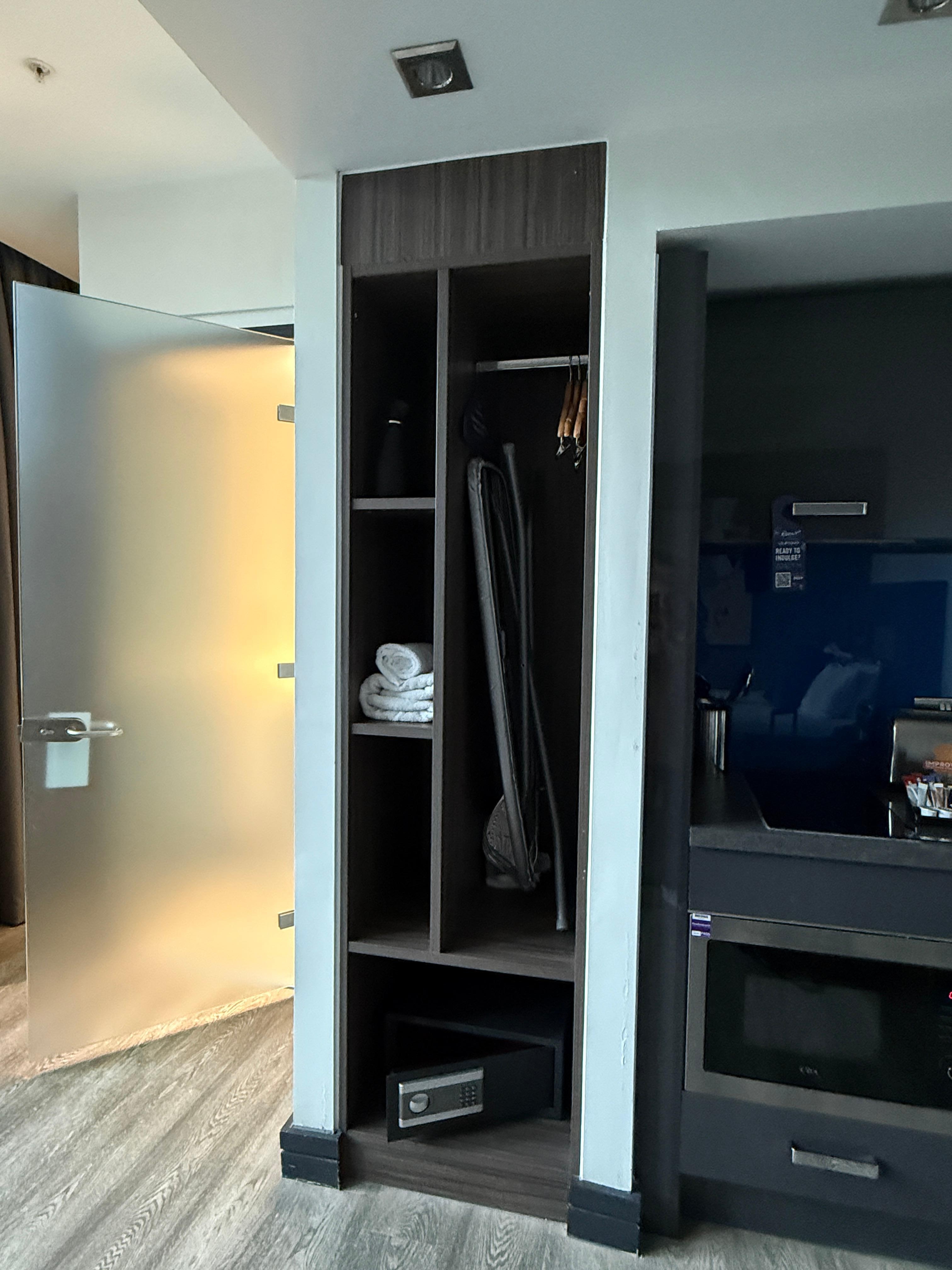 Closet area with iron and safe.