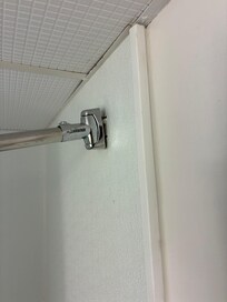 Poor wall anchoring to secure shower curtain rod. Poor wall paneling.