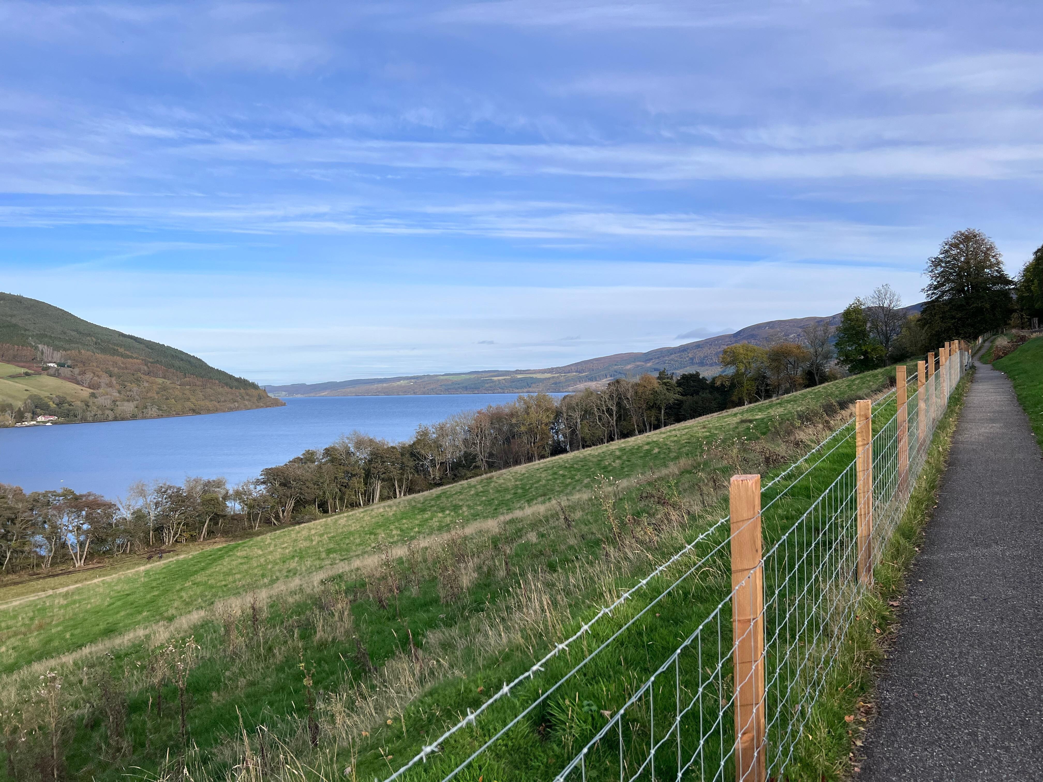 Fence along the trail with breath taking views of the mountains, loch, and farms.