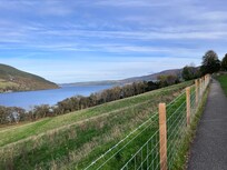 Fence along the trail with breath taking views of the mountains, loch, and farms.
