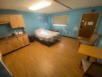 Overol room- cracks in wood floor, beat up walls.
