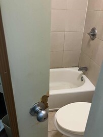 Bathroom door broken from a forced entry.