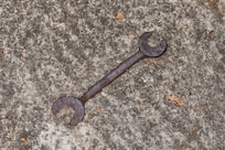Old wrench embedded into driveway