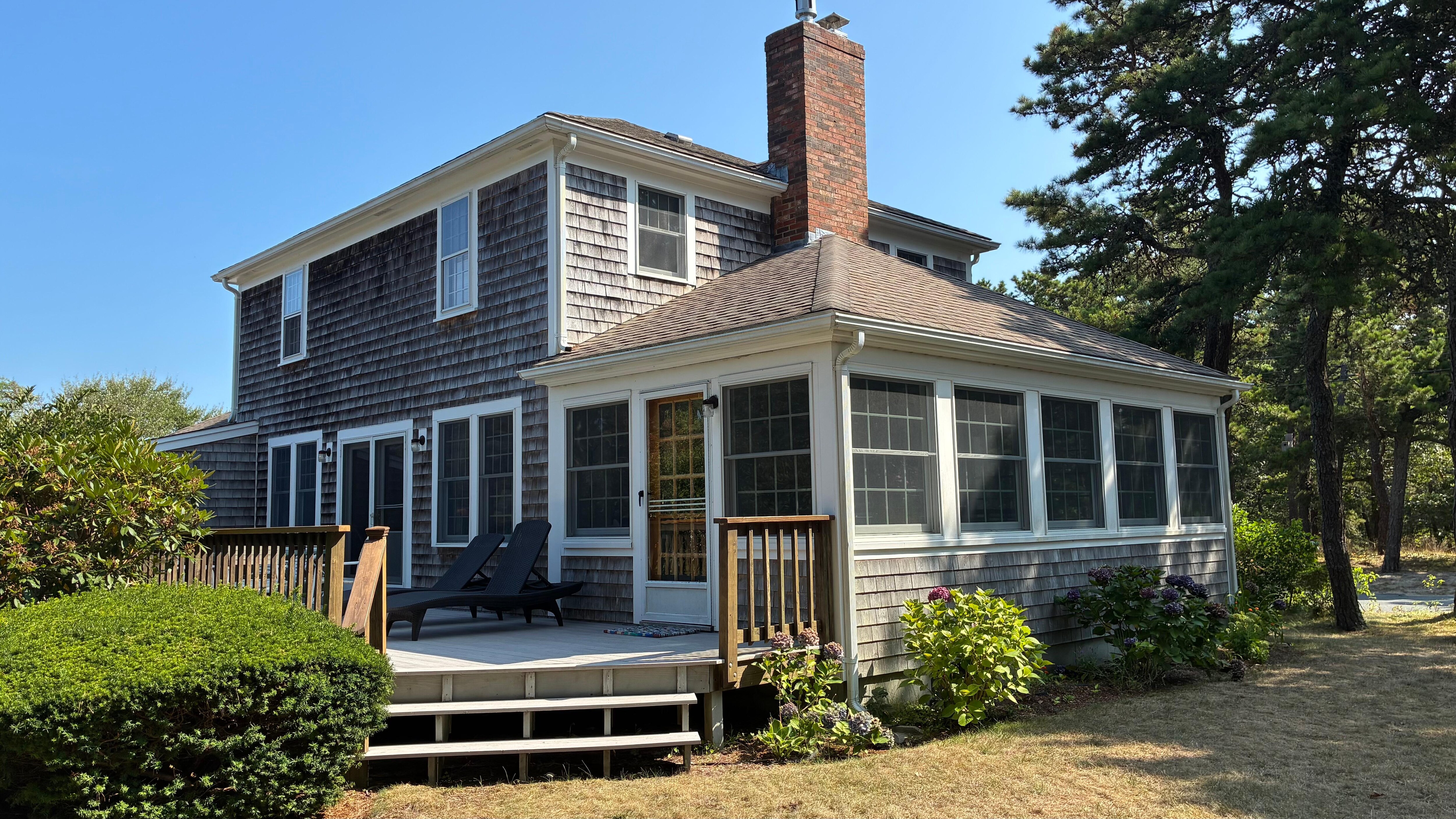 Back yard view of screened porch and deck