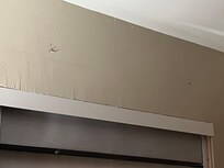 Holes above window and water damage room 223