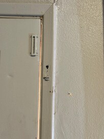 Noticeable gap in the door. Holes for the peephole and through the frame.