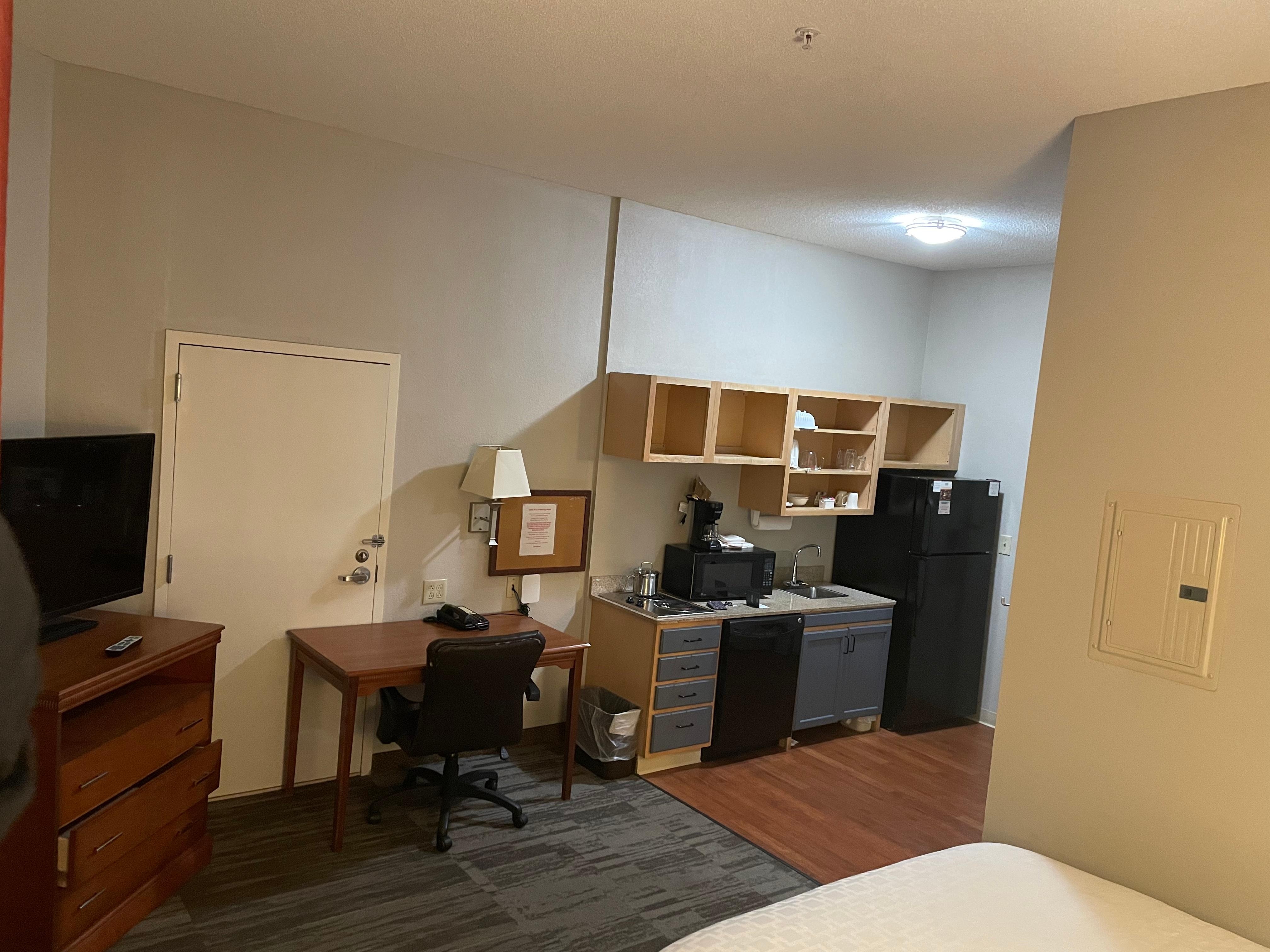 View of bedroom side with TV stand desk & window to left. 