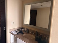 The bathroom sink and big mirror .