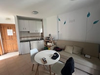 Cuisinette avec 3 ronds, réfrigérateur et couverts pour 3 personnes. Le divan fait un lit pour une 3e personne