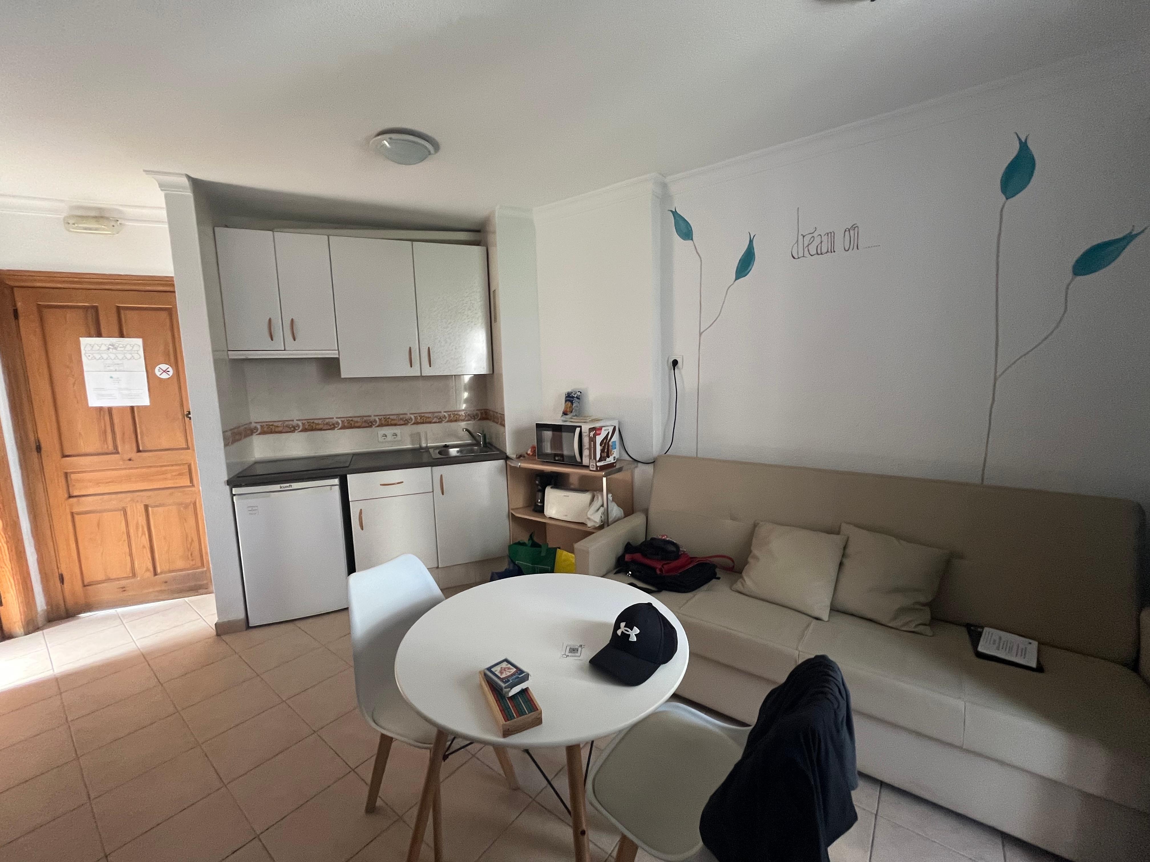 Cuisinette avec 3 ronds, réfrigérateur et couverts pour 3 personnes. Le divan fait un lit pour une 3e personne