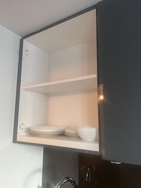 Missing cupboard door. Not many kitchen items.