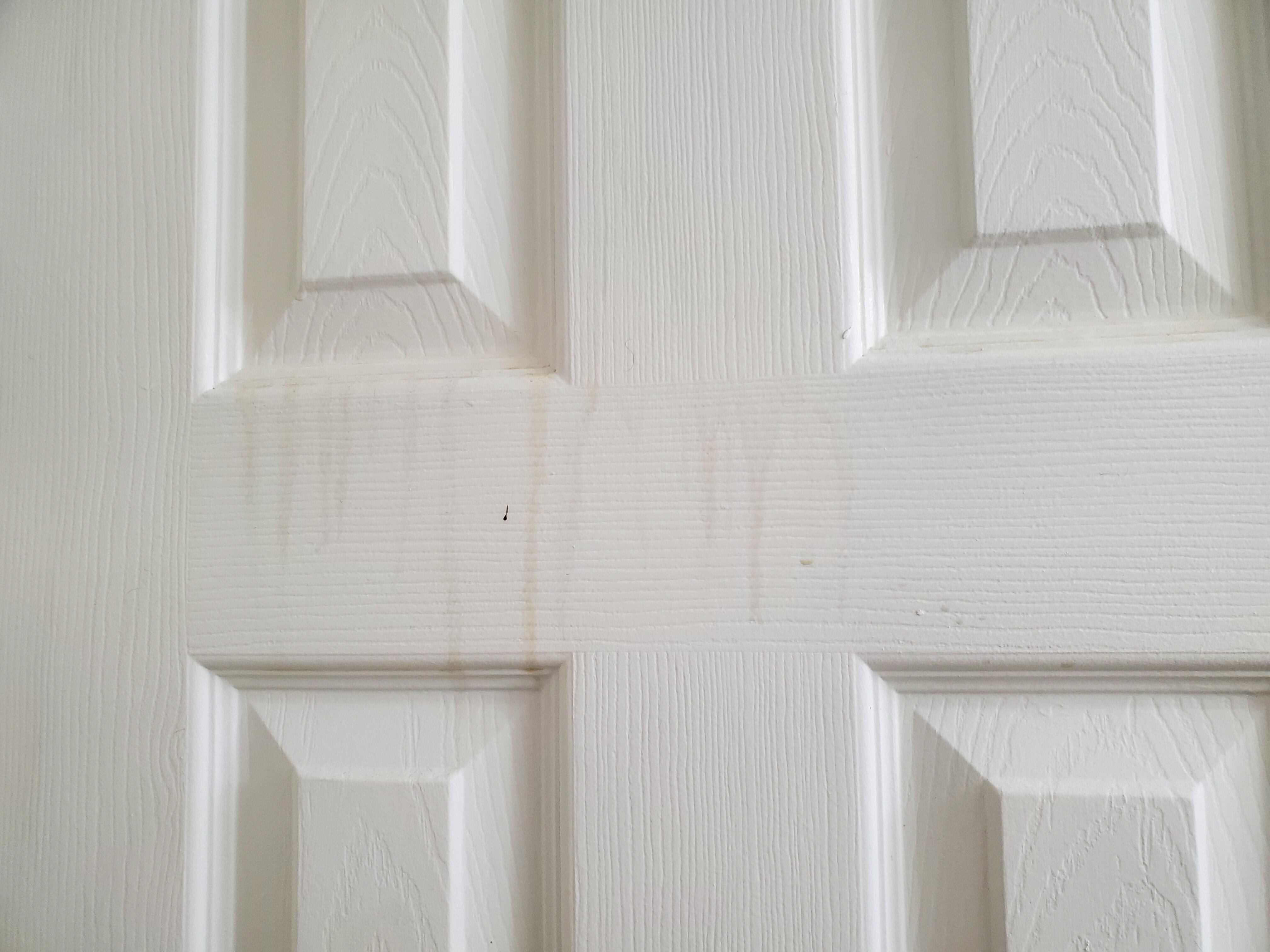 Yellow cigarette smoke stains running down bathroom door 