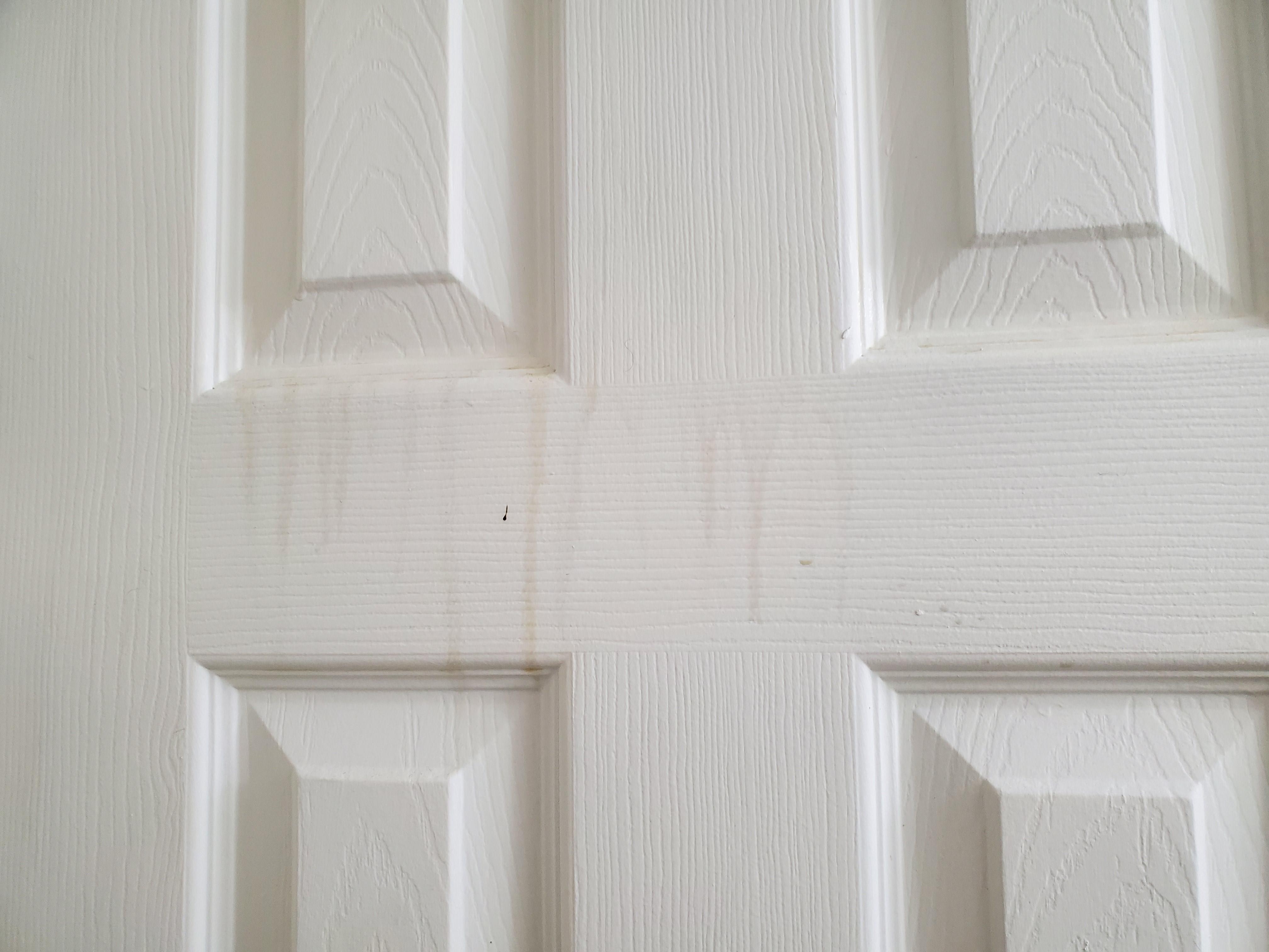 Yellow cigarette smoke stains running down bathroom door