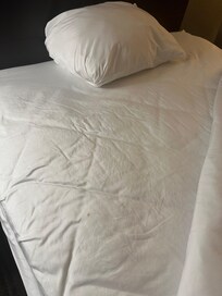 Clearly used bedsheets with stains.